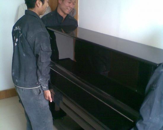 工人抬立式钢琴下楼